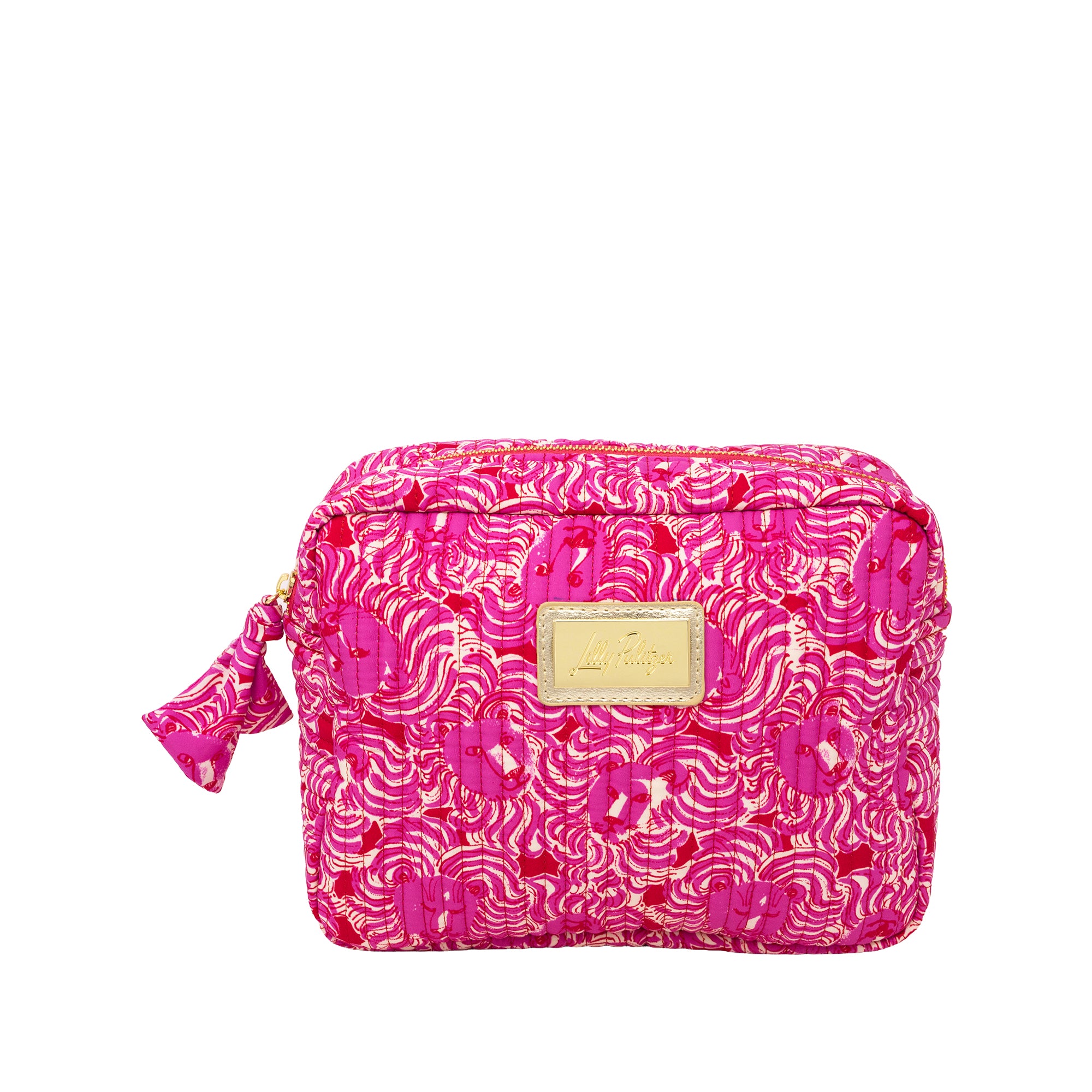 A bright pink cosmetic pouch with a gold and pink abstract wave pattern, featuring a gold-tone metal brand plaque on the front and a matching pink tassel zipper pull.