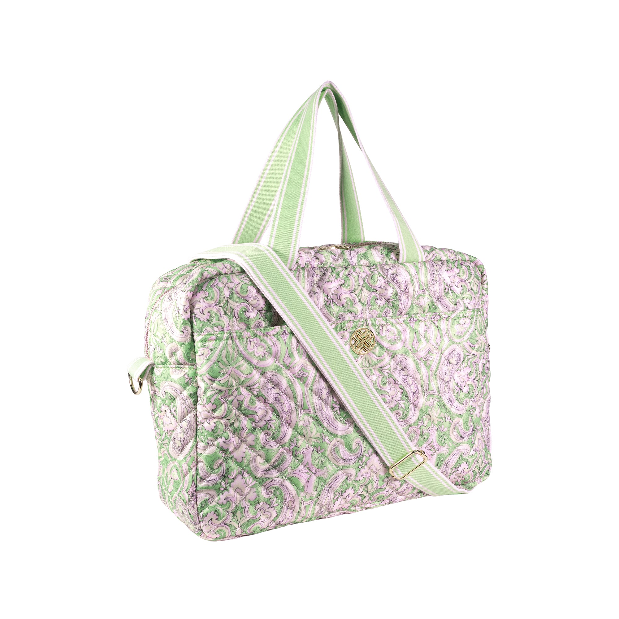 A quilted duffel bag with a light green and lavender paisley pattern, featuring light green handles and a matching shoulder strap with a gold-tone logo clasp.