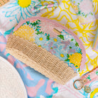 Floral-patterned pouch with a wicker base on a colorful background