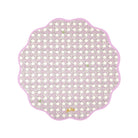 A round, scalloped-edge placemat with a white and light pink geometric lattice pattern and a light pink border, featuring a small gold 'J' logo at the bottom.