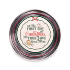 A round tin with a silver metal lid featuring a festive Christmas design. The lid has a cream-colored center with the text 'ON THE FIRST DAY OF CHRISTMAS, MY TRUE LOVE I GAVE TO ME' in green and red lettering, surrounded by a wreath border, a small bird, and a red bow.