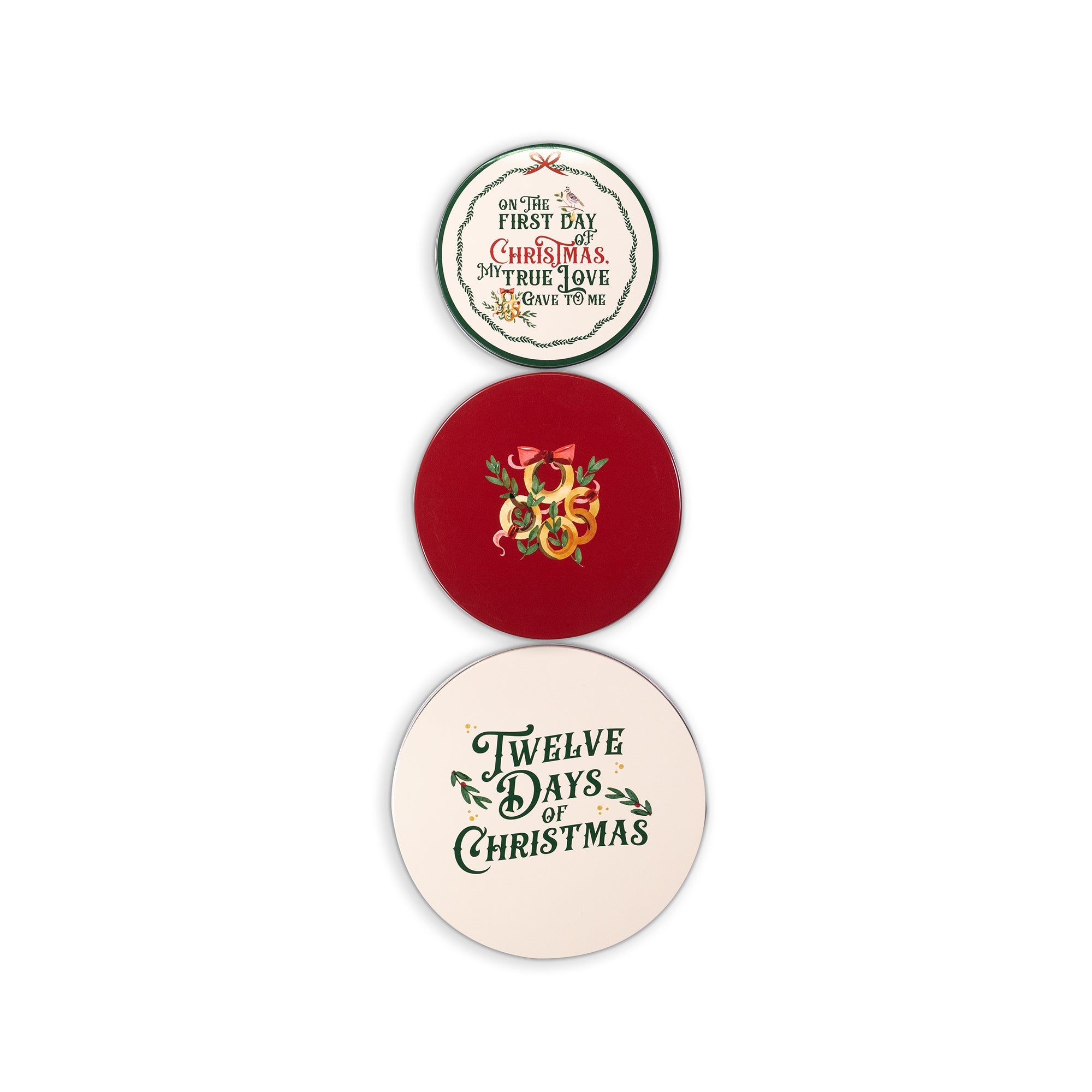 Three round Christmas-themed tin lids stacked vertically on a white background. The top sticker is cream with green and red text reading 'On the First Day Christmas'