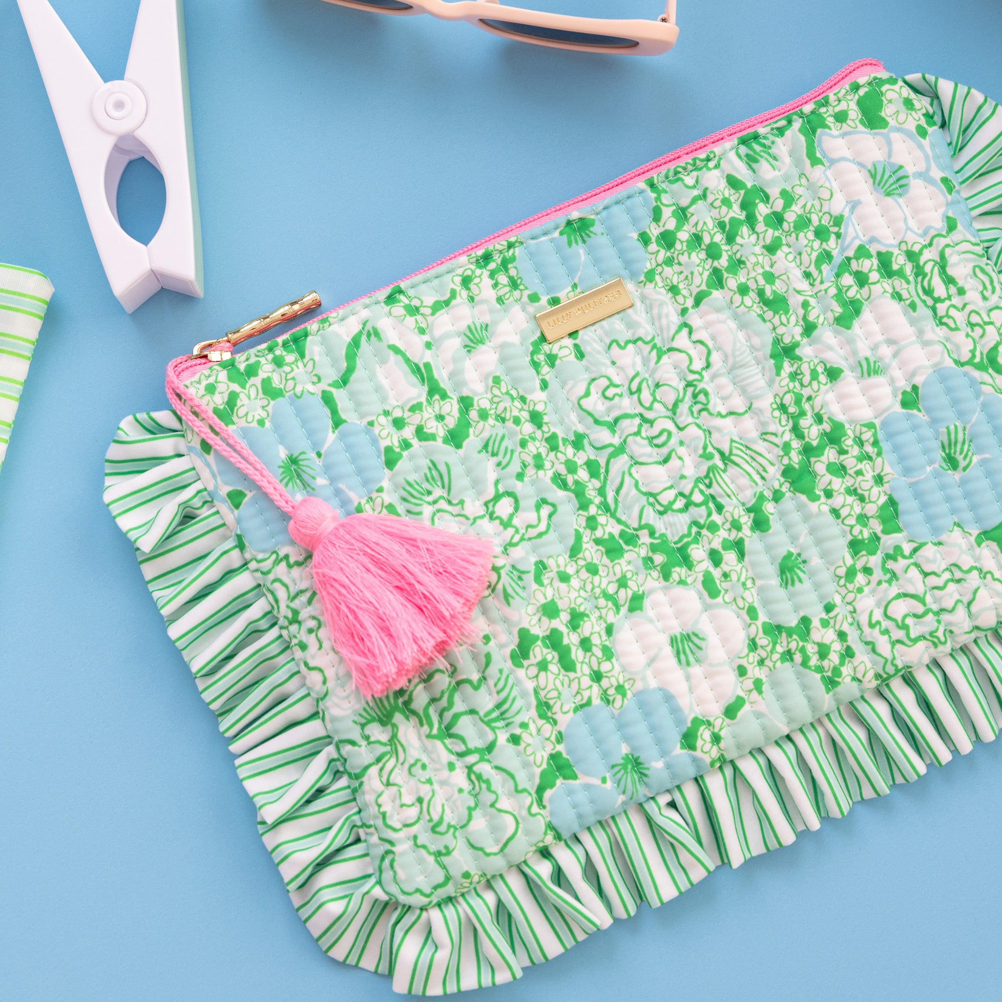 Floral patterned pouch with a pink tassel on a white background