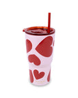 Pink tumbler with red heart patterns and a straw on a white background