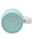 Mint green mug with a white handle on a white background