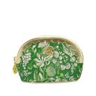 A green cosmetic pouch with a white botanical and fruit pattern, featuring gold-toned trim, a scalloped zipper edge, and a gold circular logo medallion on the front.