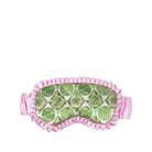 A pink sleep mask with a green and white  pattern on the front, finished with a ruffled satin trim and an elastic strap, shown against a plain white background.