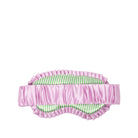 A pink satin sleep mask with ruffled trim and a green and white striped inner lining, shown against a plain white background.