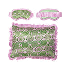 A decorative throw pillowcase with a pink and green botanical pattern and fringed edges, shown against a plain white background with matching eye mask