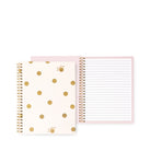 A spiral-bound notebook with a cream cover decorated with gold polka dots and small gold floral details, shown next to an open lined notebook page with a light pink border.