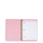 An open pink spiral-bound notebook with lined pages and a lined pocket page on the left, photographed on a clean white background.