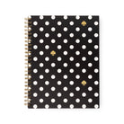 A spiral-bound notebook with a black cover decorated with white polka dots and three gold spade icons, shown on a plain white background.