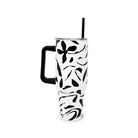 White tumbler with black floral pattern and handle on a white background