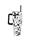 White tumbler with black floral pattern and handle on a white background