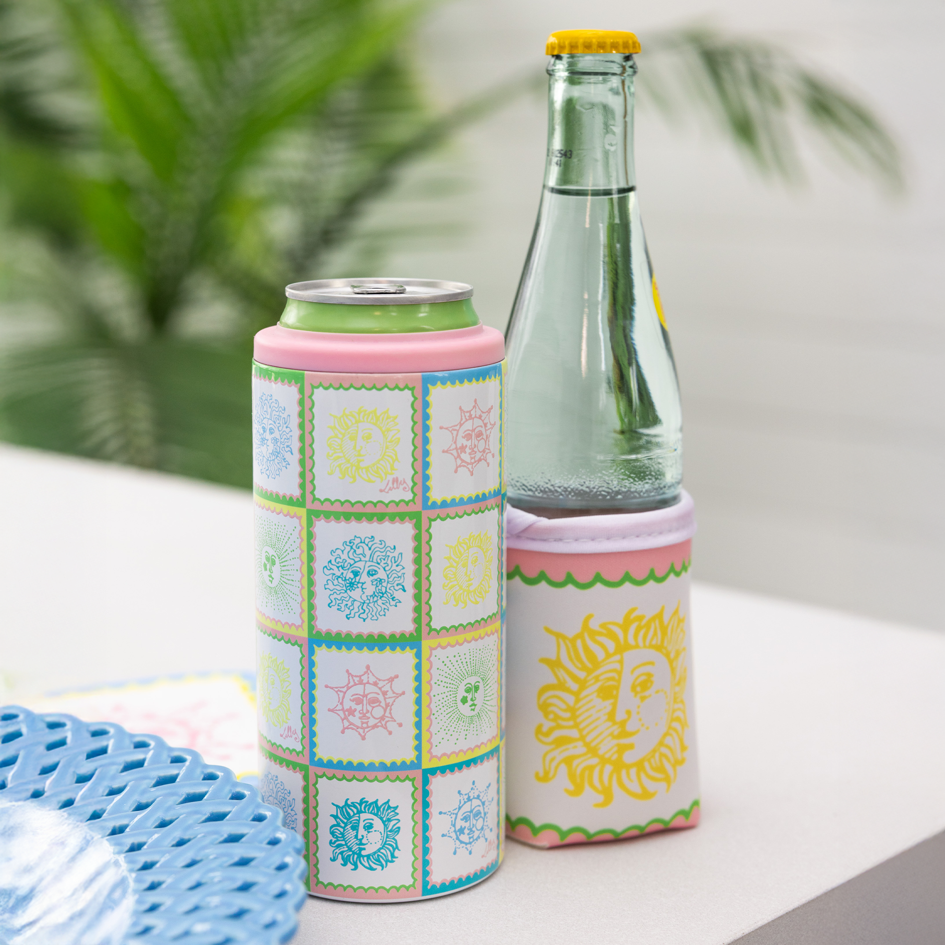 Two can coolers with colorful designs on a white surface.