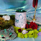 Pink tumbler with rose and butterfly design with a rose and moss background