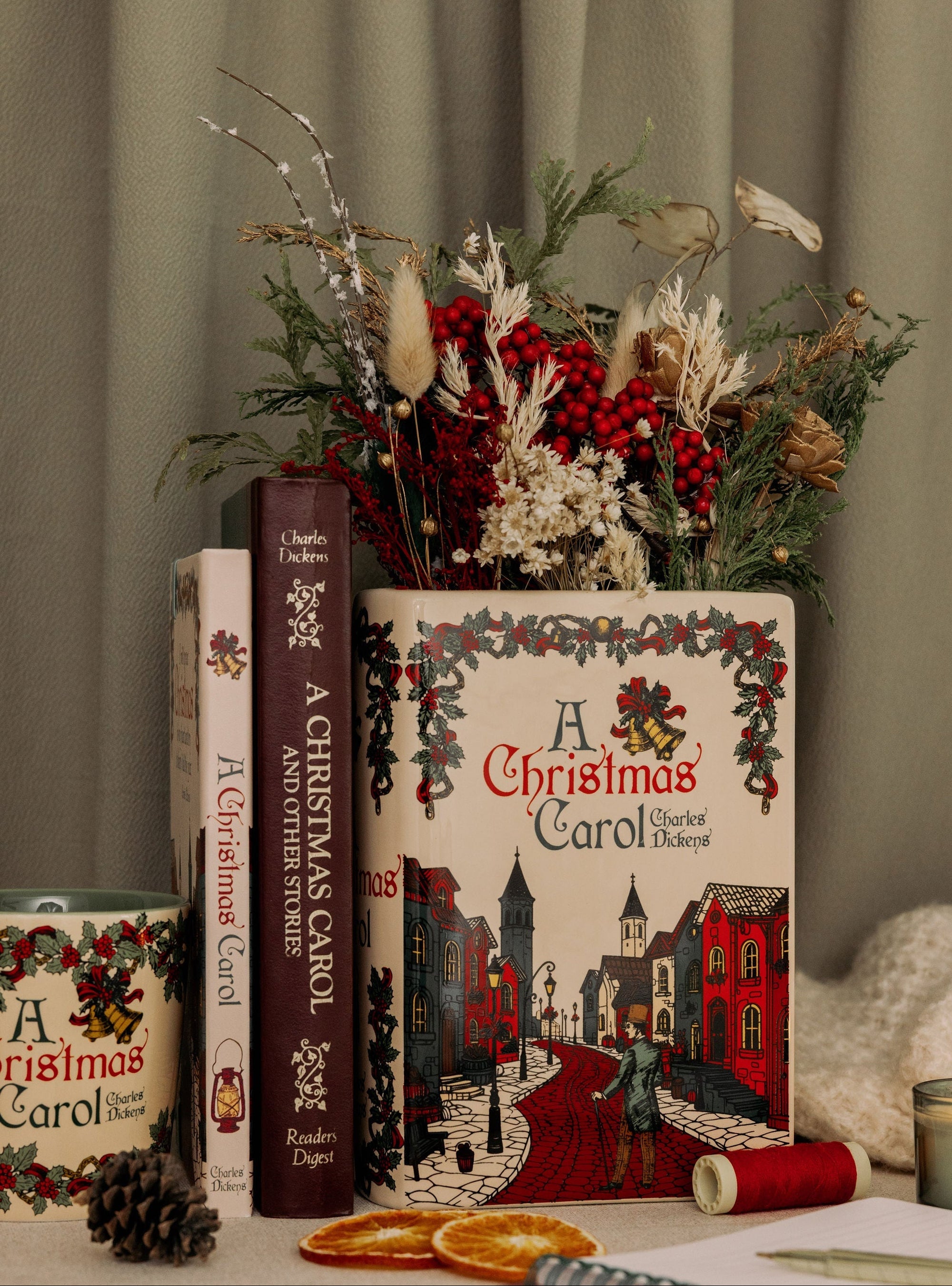 Decorative setup with 'A Christmas Carol' books and a candle on a table.