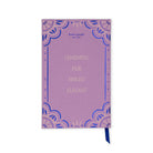 A Kate Spade New York notebook with a lavender purple cover, featuring blue ornate lace-like corner patterns and gold foil text that reads 'CHARMING FAIR BRIGHT ELEGANT.' A dark blue ribbon bookmark hangs from the bottom right corner.