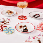 ceramic plates scattered on a table setting with coupe drink, cocktail napkins and leatherette candy coasters