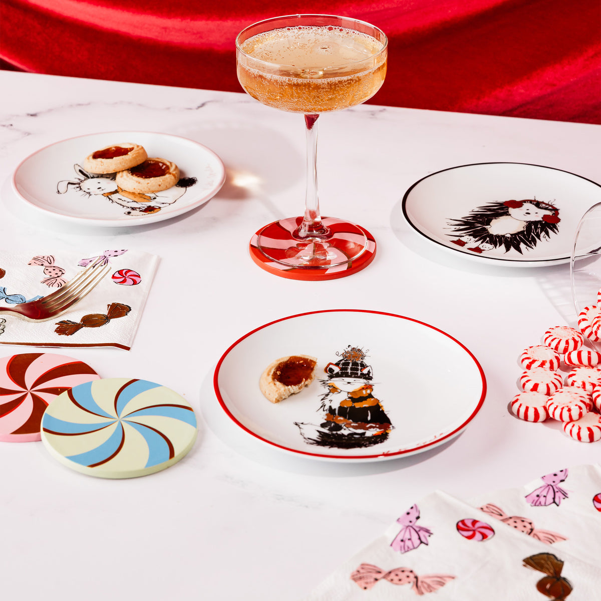 ceramic plates scattered on a table setting with coupe drink, cocktail napkins and leatherette candy coasters