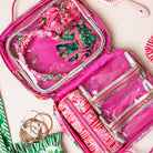 interior of rectangular cosmetic bag with a vibrant pink, red, and green floral print on a cream background, featuring pink handles and a gold-tone brand plaque.