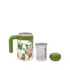 Floral mug with green handle and lid, metal infuser, and green base on a white background