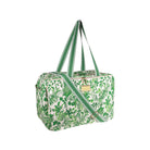 A green and white botanical print duffel bag with green and white striped handles and a matching diagonal shoulder strap, featuring a small gold-tone metal plaque on the front.