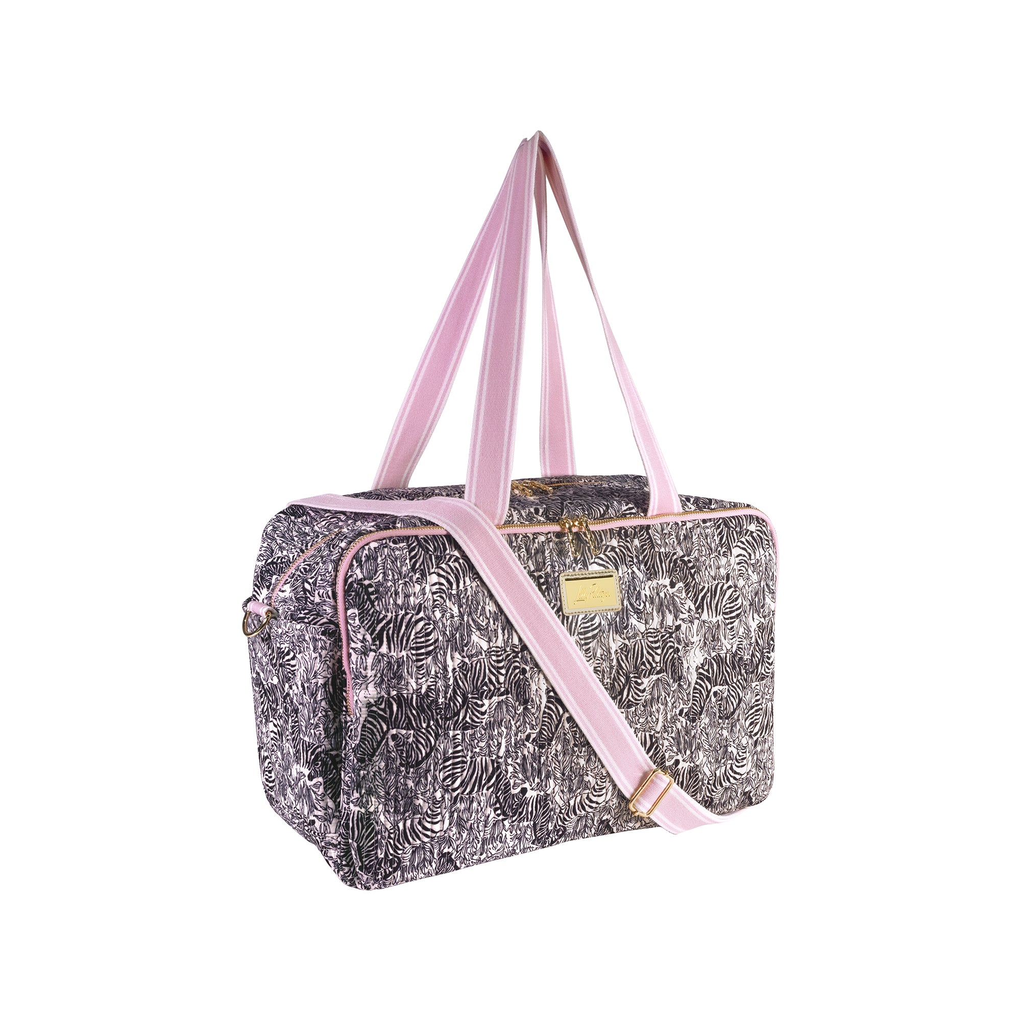A rectangular duffel bag with a black and white tropical leaf pattern, featuring light pink straps, trim, and a small gold metal brand plaque on the front.