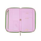A pink zip-around wallet shown open, featuring light green zipper trim, interior card slots, a clear ID window, and gold lettering including 'ticket', 'passport', and a signature logo.
