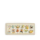 A rectangular ceramic tray with a cream-colored background, featuring a row of colorful illustrated motifs including birds, a basket, a figure in a dress, a flower, and a drum, bordered in gold.
