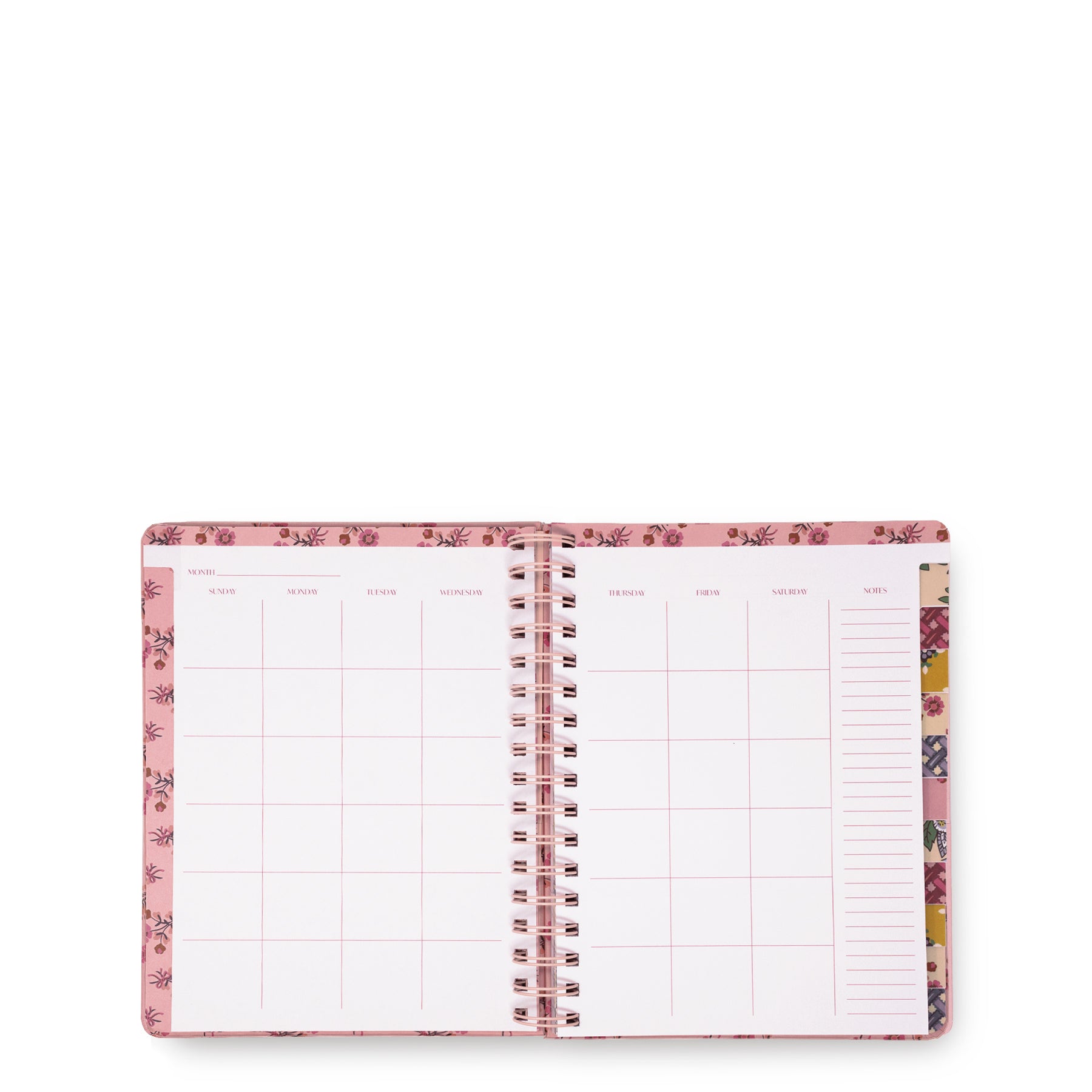 An open spiral-bound planner or agenda with pink floral-patterned covers and white interior pages featuring grid and lined sections, photographed on a plain white background.