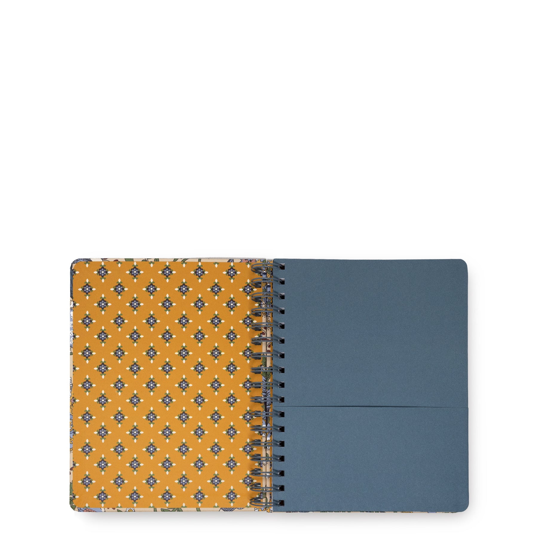A spiral-bound notebook shown open against a plain white background. The left page has a mustard yellow cover with a repeating blue and white geometric pattern, and the right page is a solid muted blue-gray.