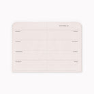 A light blush pink weekly planner insert or notepad page with rounded corners, featuring labeled sections for Monday through Friday, Saturday and Sunday, and a notes column under the heading 'THIS WEEK IS'.