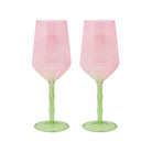 Two pink and green translucent wine glasses with a bulbous bowl and ribbed stems, shown side by side on a white background.