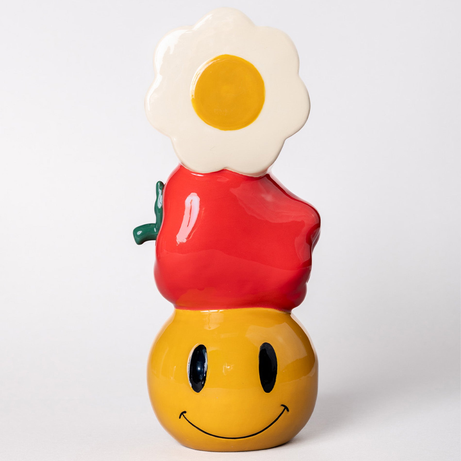 Ceramic stacked vase with white daisy, apple, and yellow smiley