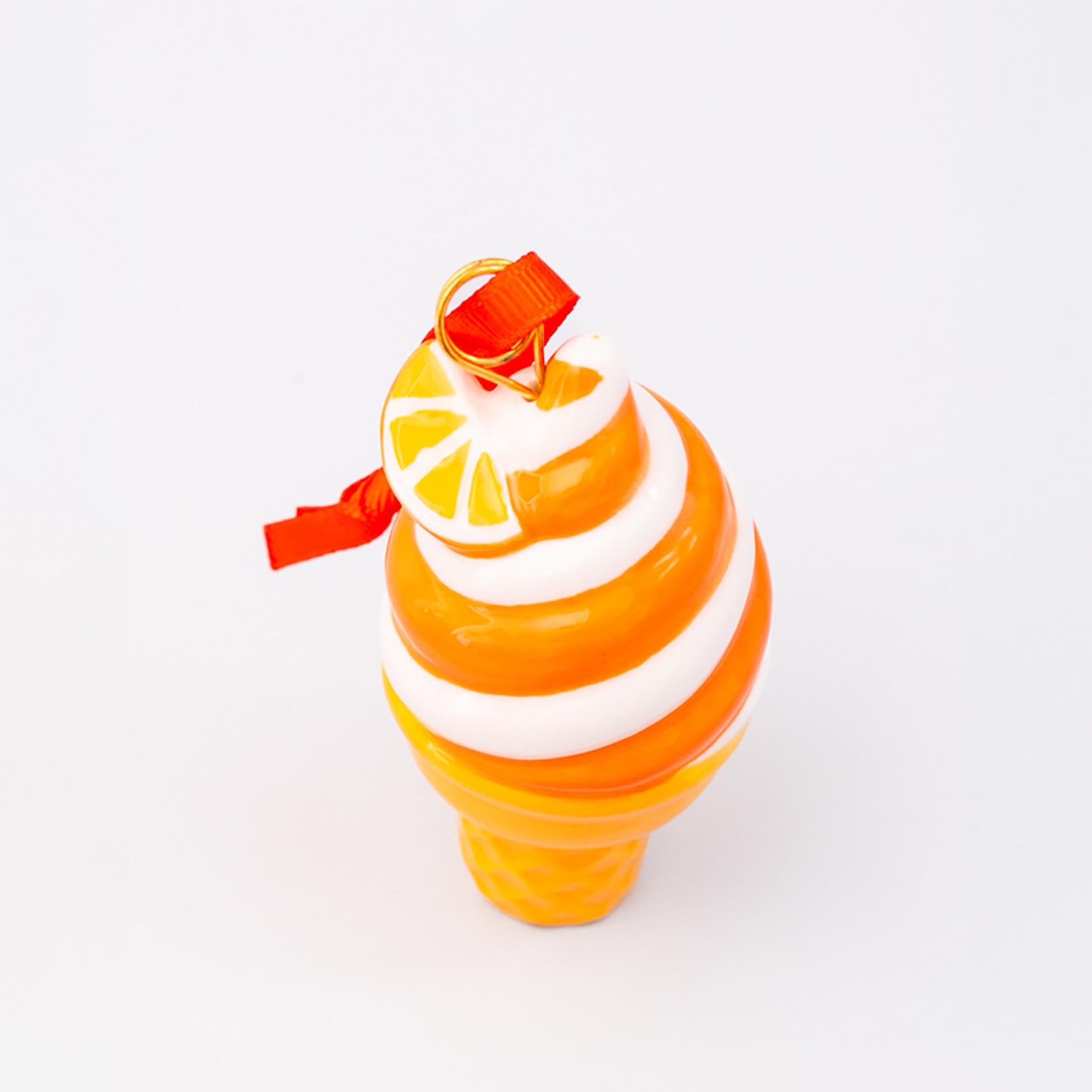 Ice cream ornament with orange and white design on a white background