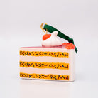 Decorative cake-shaped ornament with a cherry on top against a white background
