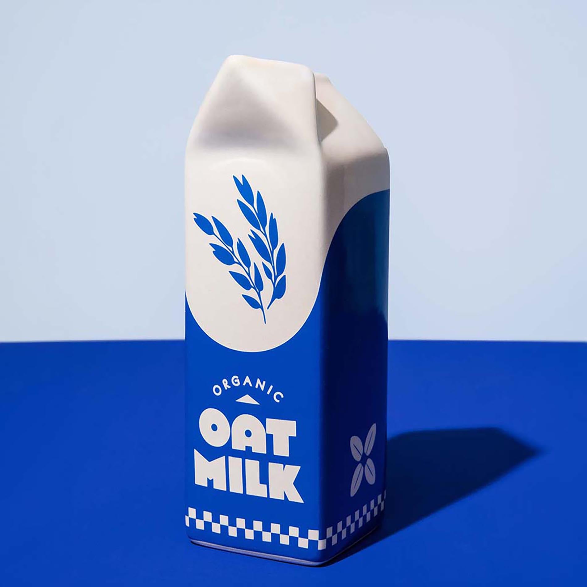 Carton of organic oat milk vase with a blue and white design on a blue background