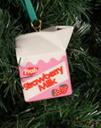 Decorative ornament shaped like a strawberry milk carton hanging on a Christmas tree.