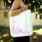 reversed floral sketch of white tote with pink strap and lettering that says 'I love you...thorns and all' with a sketched floral print
