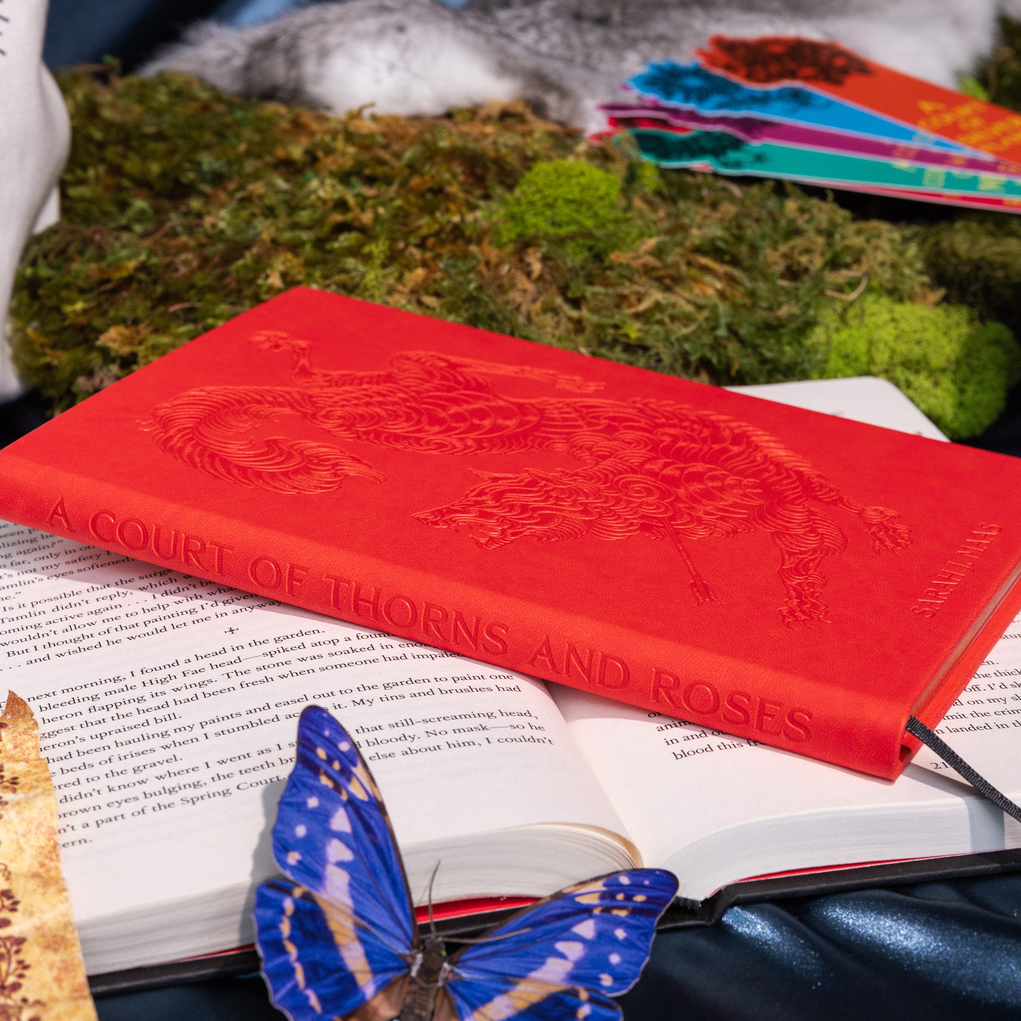 Red book titled 'A Court of Thorns and Roses' with a butterfly on an open book