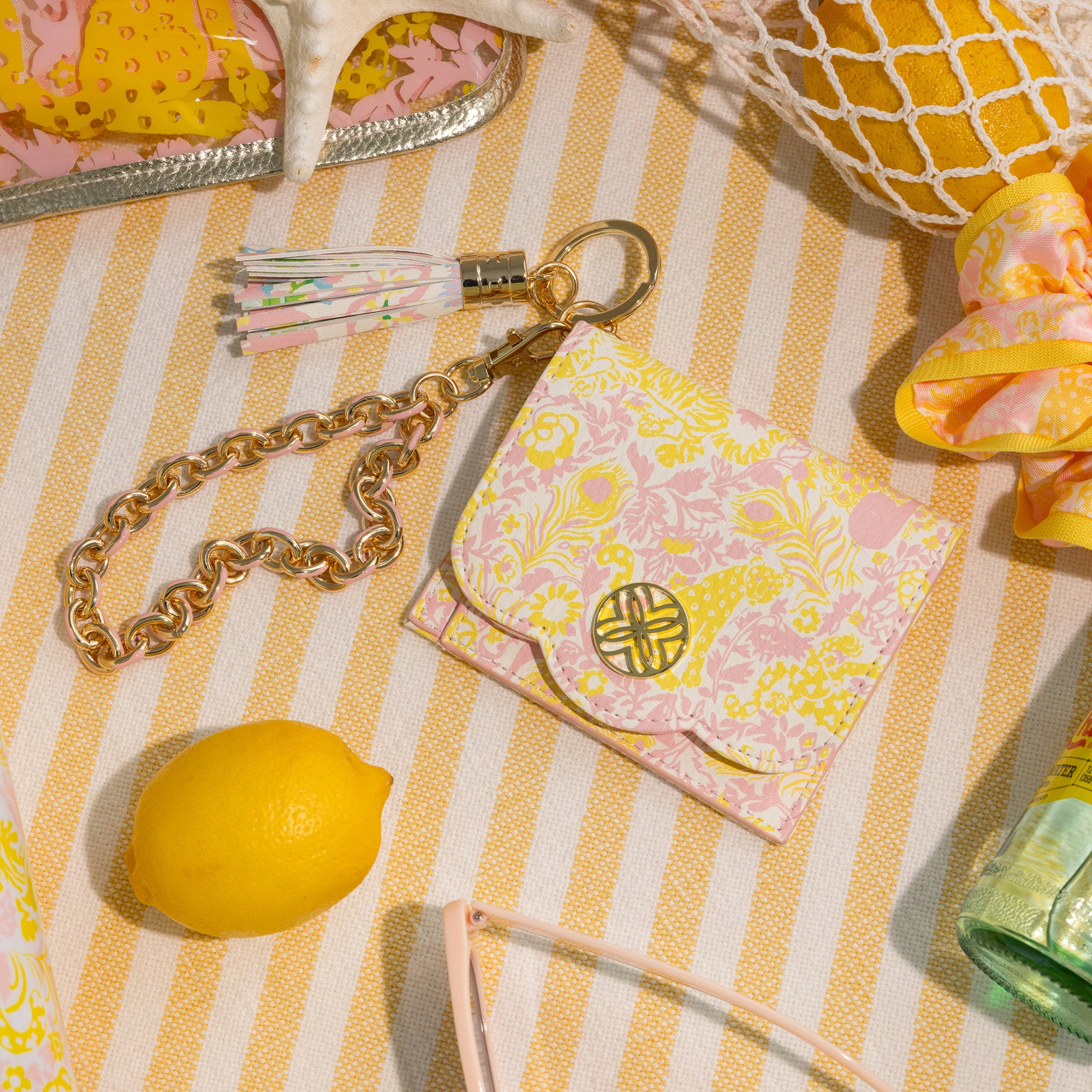 Decorative items including a lemon, keychain, and small pouch on a striped surface.