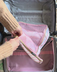 model showcasing pink and white stripe travel accessories