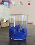 model making a coffee drink in a glass cup with blue design on the bottom