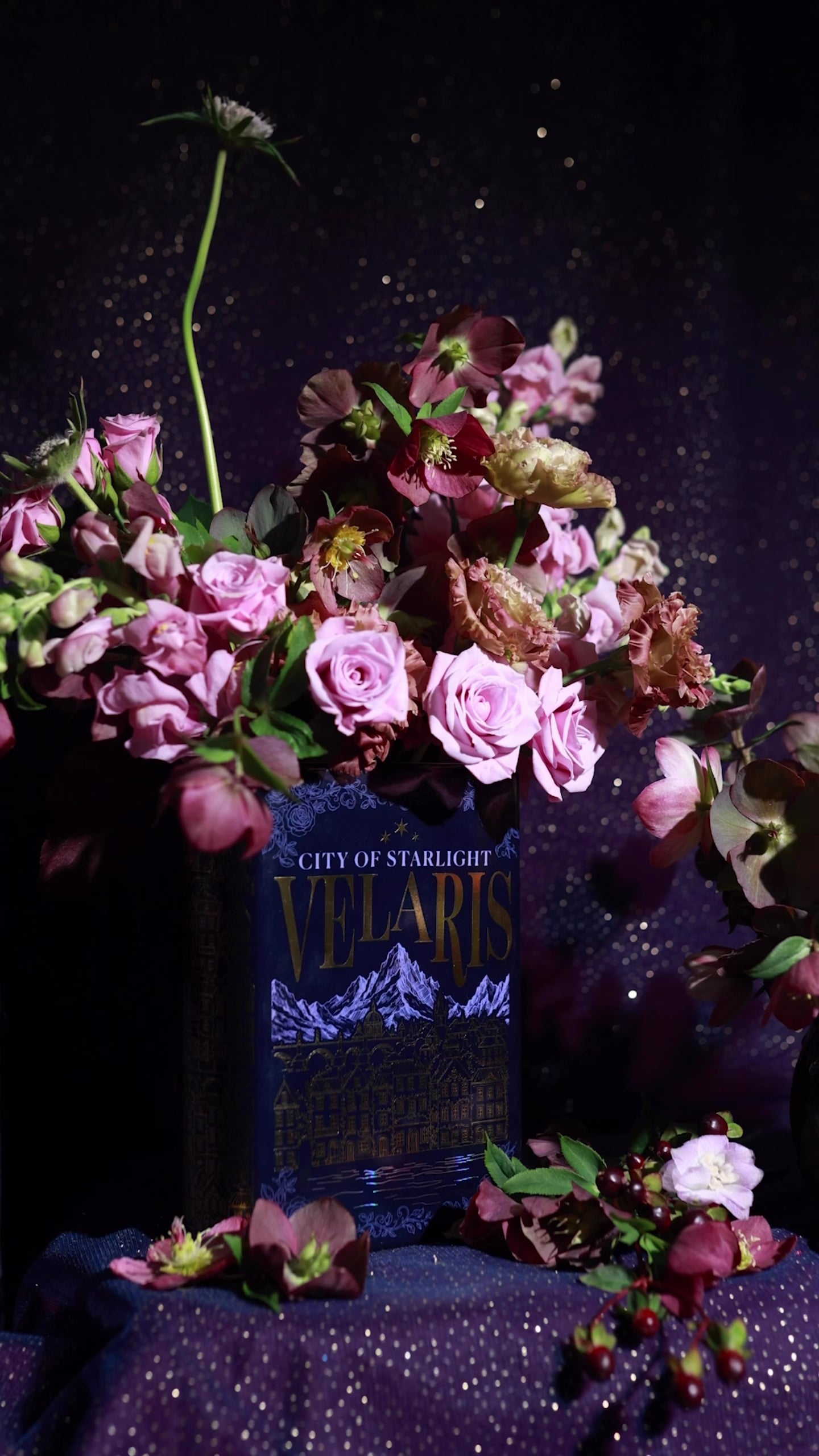 Book-shaped vase with 'Velaris' design with a bouquet inside