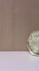 model showcasing quilted travel bag featuring a light green and pink paisley pattern, with matching green and white striped handles and a green adjustable shoulder strap, shown on a plain white background.